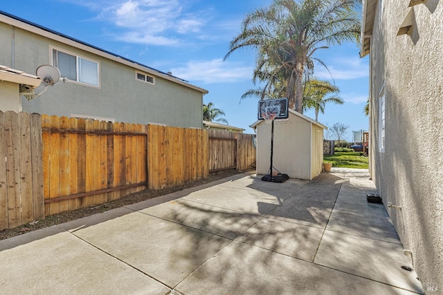 view of patio with an outbuilding, a storage shed, and fence