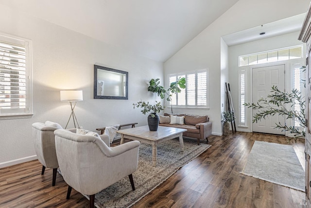 living room with high vaulted ceiling, baseboards, and wood finished floors