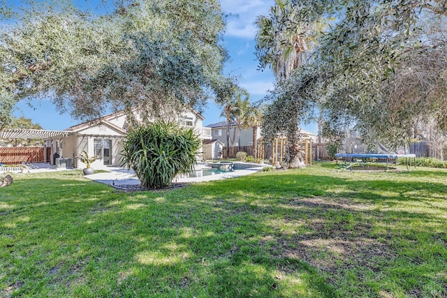 view of yard featuring a patio, a fenced backyard, a trampoline, an outdoor structure, and a pergola