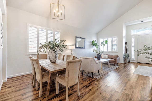 dining space featuring high vaulted ceiling, an inviting chandelier, baseboards, and wood finished floors