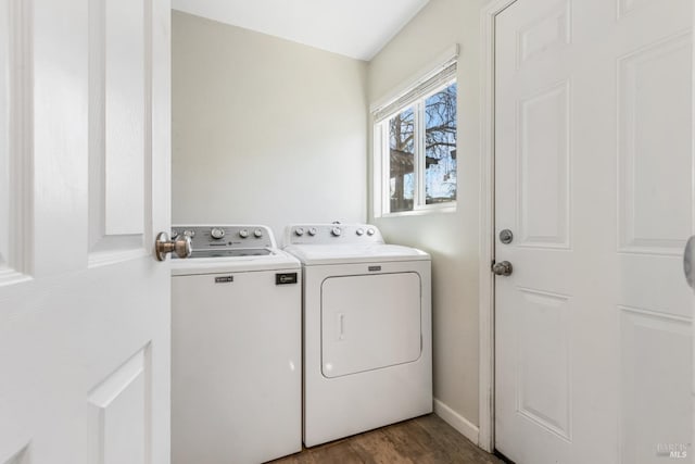 laundry area with baseboards, laundry area, wood finished floors, and washer and dryer