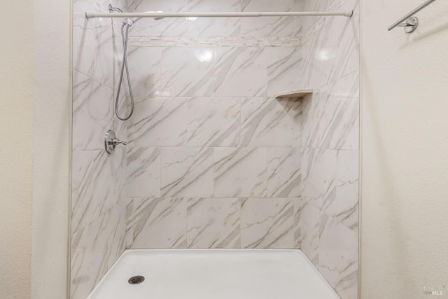 bathroom with a marble finish shower