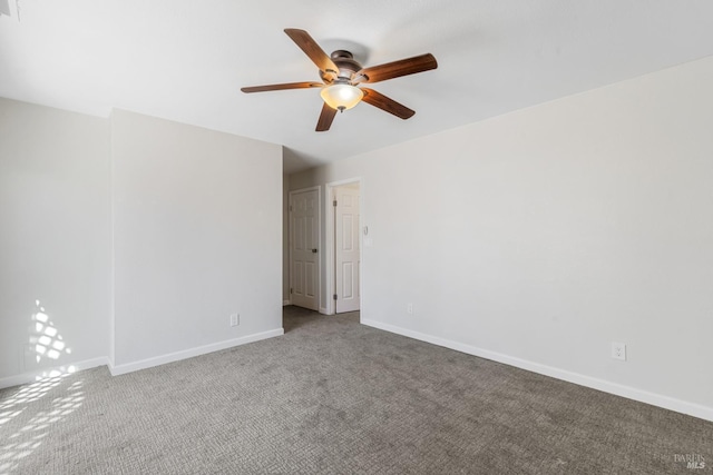empty room with carpet flooring, baseboards, and a ceiling fan
