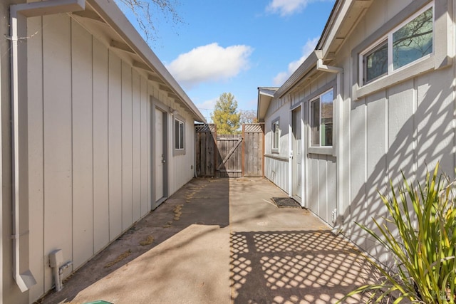 view of side of property with a gate, a patio, and fence