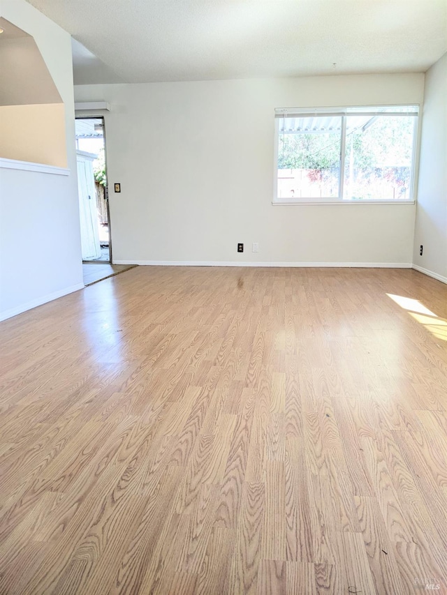 unfurnished room featuring light wood-type flooring and baseboards