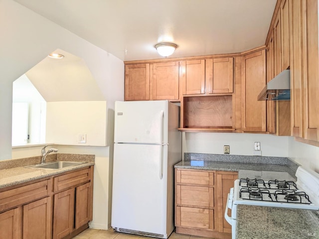 kitchen with white appliances, light tile patterned floors, light stone countertops, under cabinet range hood, and a sink