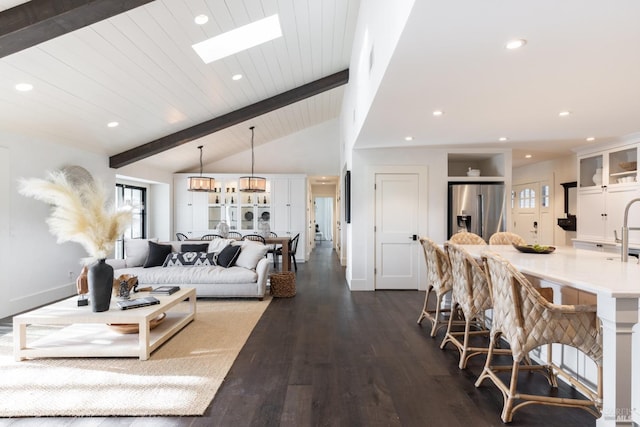 living room featuring dark wood-style floors, vaulted ceiling with skylight, baseboards, and recessed lighting