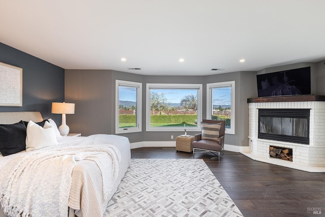 bedroom featuring recessed lighting, dark wood-type flooring, a fireplace, visible vents, and baseboards