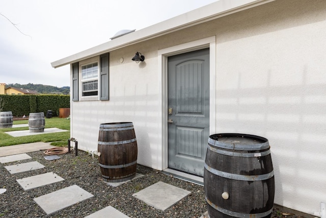 entrance to property featuring fence and stucco siding