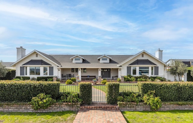 view of front of house featuring a fenced front yard and a chimney