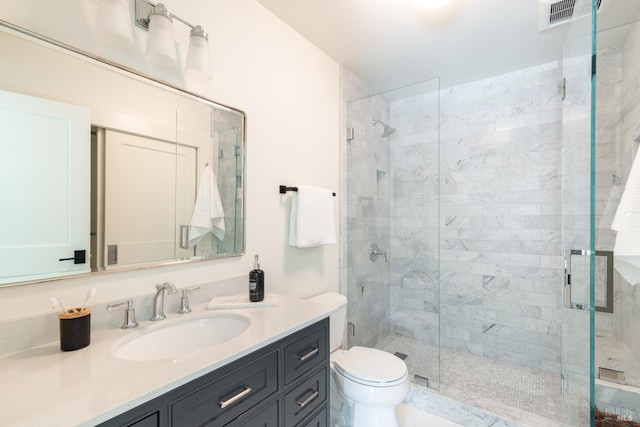 full bathroom featuring toilet, a stall shower, visible vents, and vanity