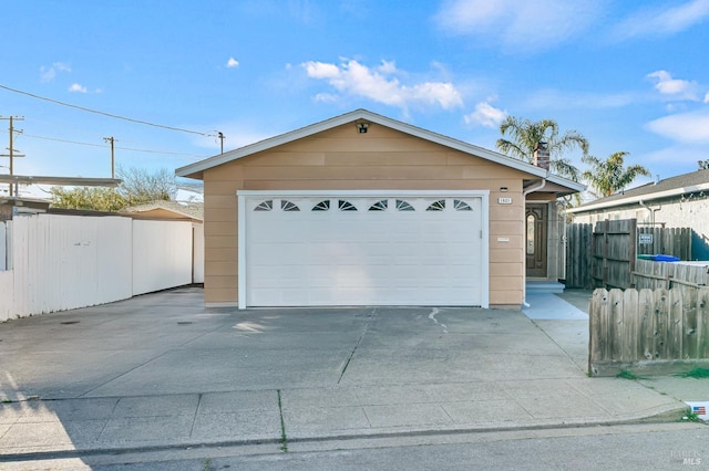 detached garage featuring fence