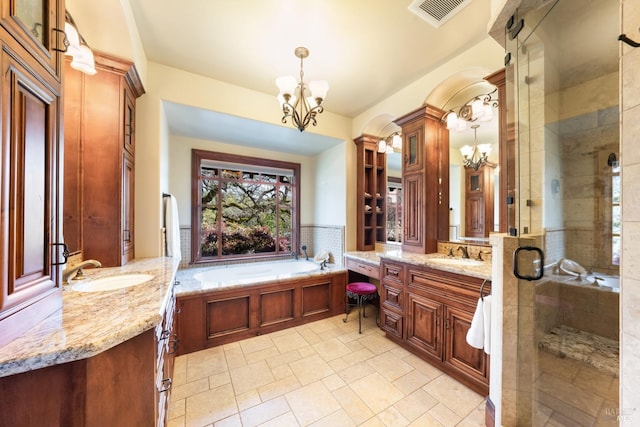 full bathroom with visible vents, two vanities, a sink, a shower stall, and a chandelier