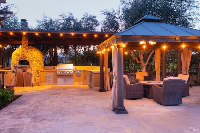 view of patio / terrace with a gazebo, area for grilling, and a fireplace