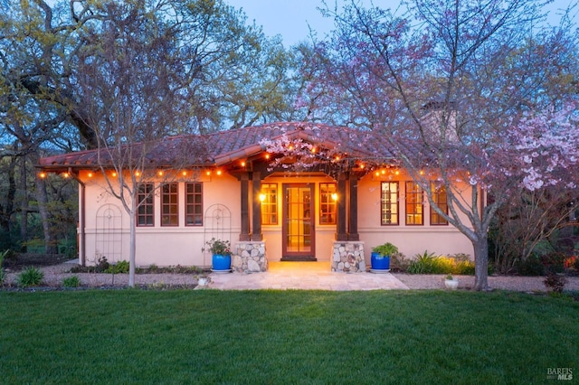 view of front of property with a patio area, stucco siding, and a front lawn