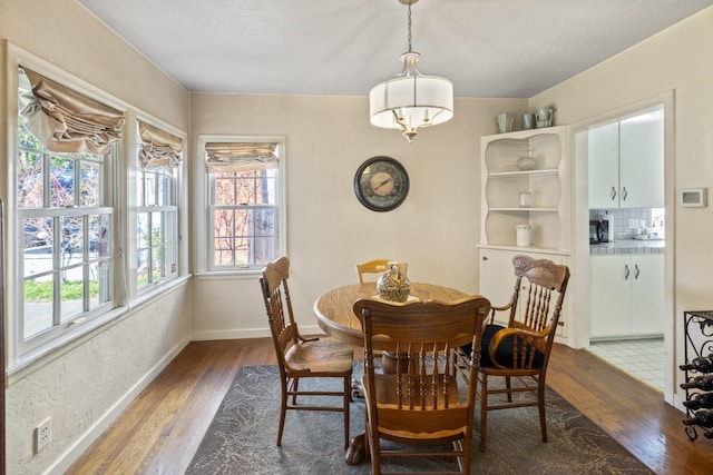 dining space featuring baseboards and wood finished floors