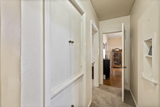 hallway with light colored carpet and baseboards