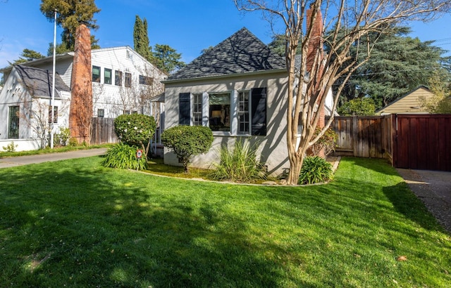 view of front of home featuring fence, a front yard, and stucco siding