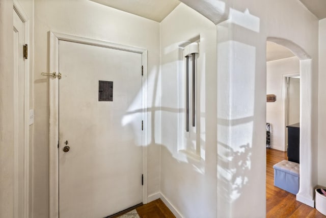interior space featuring arched walkways and dark wood-style floors