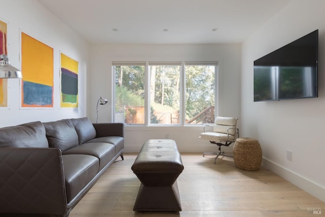 living area with baseboards and wood finished floors