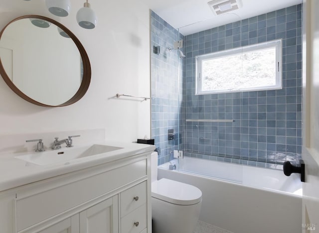 full bathroom with toilet,  shower combination, vanity, and visible vents