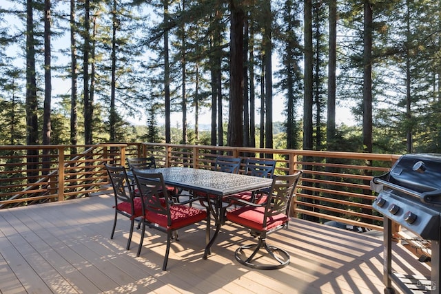 wooden deck featuring outdoor dining space and a grill