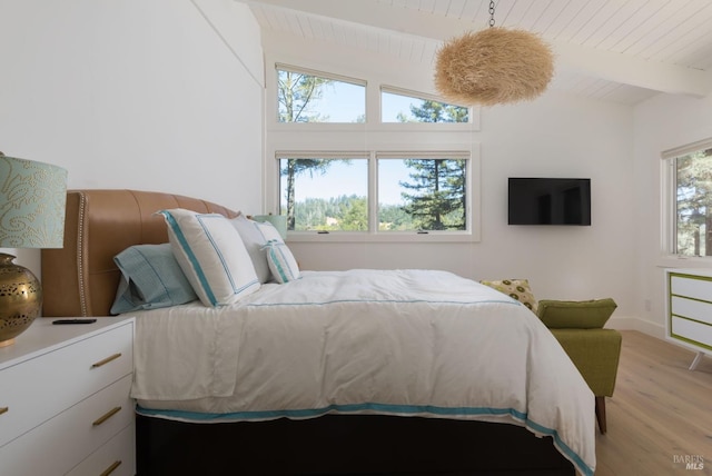 bedroom with vaulted ceiling with beams, light wood finished floors, and wood ceiling