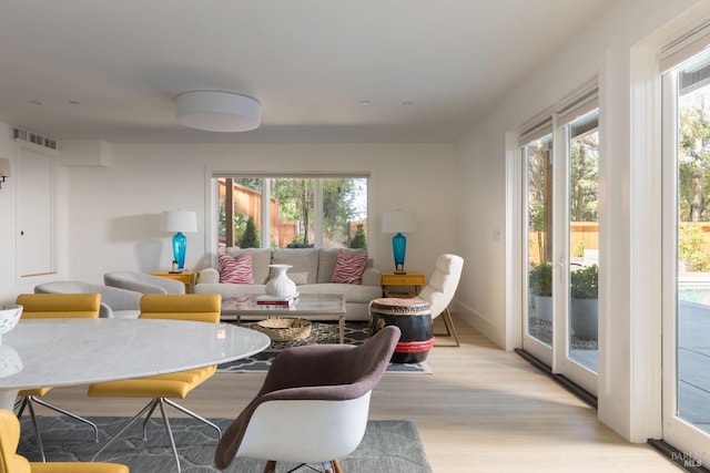 living area featuring light wood finished floors, visible vents, and a wealth of natural light