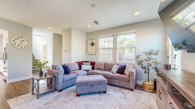 living area featuring stairs, visible vents, light wood-style flooring, and recessed lighting