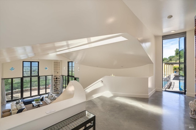 hall featuring concrete floors and baseboards