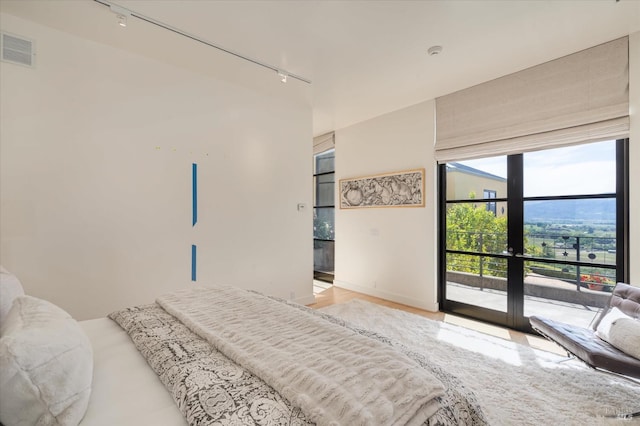 bedroom featuring visible vents, access to exterior, track lighting, and french doors