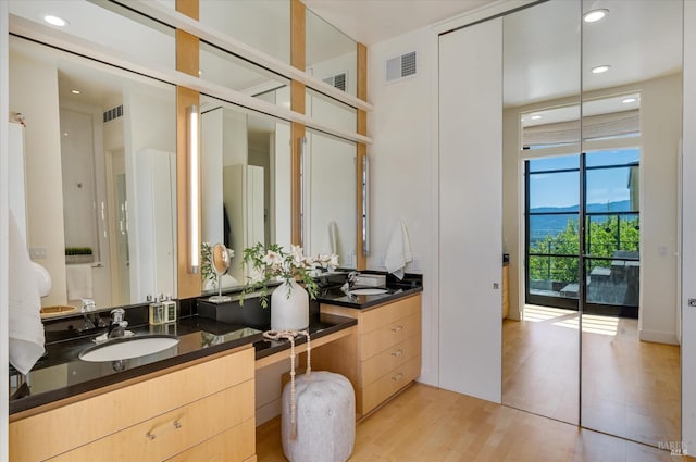 bathroom with vanity, recessed lighting, wood finished floors, and visible vents