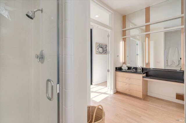 bathroom featuring a stall shower, vanity, and wood finished floors