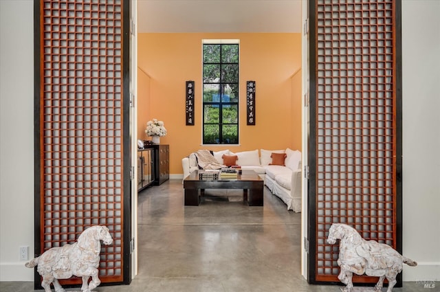 living room with baseboards and concrete floors