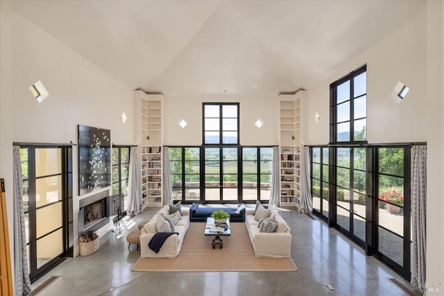 living room featuring high vaulted ceiling, a fireplace, and finished concrete floors