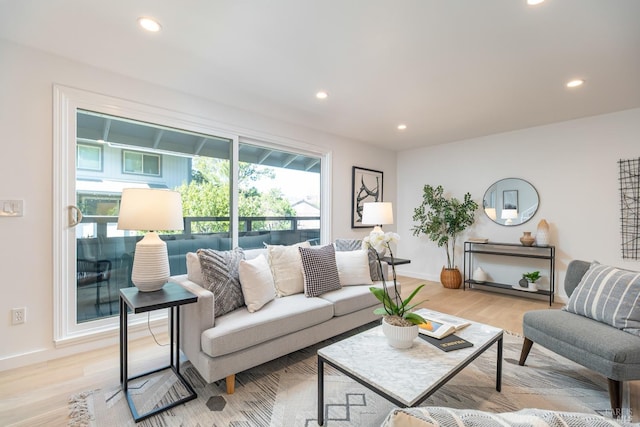 living area with light wood-type flooring, baseboards, and recessed lighting