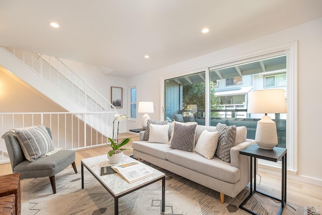 living room with light wood-style floors, stairs, and recessed lighting