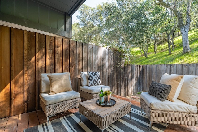 wooden deck with outdoor lounge area and fence