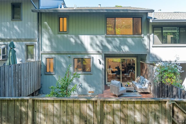 rear view of property featuring fence