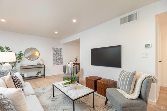 living room with baseboards, light wood finished floors, visible vents, and recessed lighting