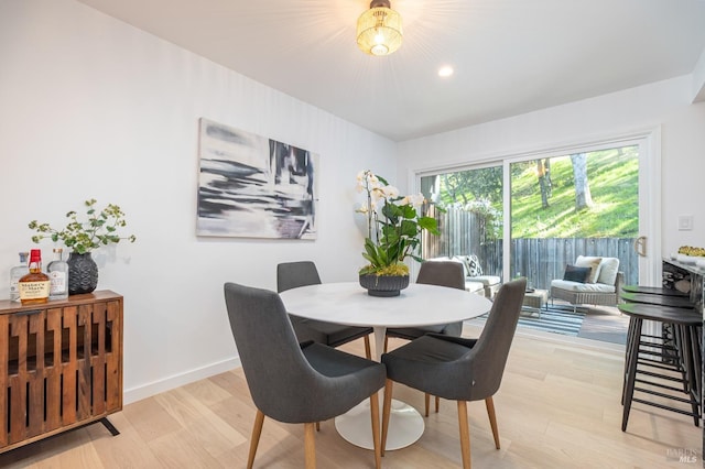 dining area with light wood-type flooring and baseboards