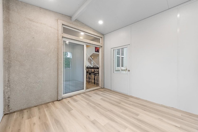 spare room featuring vaulted ceiling with beams, stairway, and wood finished floors