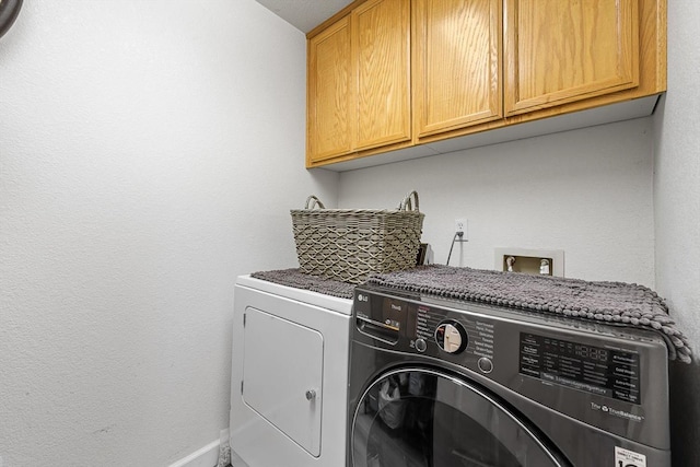 laundry area featuring cabinet space, baseboards, and washing machine and clothes dryer