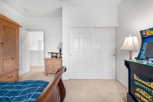 bedroom featuring baseboards, a closet, and light colored carpet