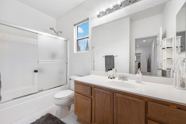 full bath with shower / bath combination with glass door, vanity, toilet, and tile patterned floors