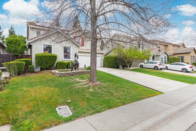 view of front of house featuring concrete driveway, a residential view, fence, a front yard, and stucco siding