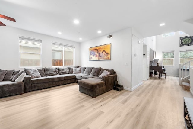 living area with light wood-type flooring, visible vents, recessed lighting, and stairs