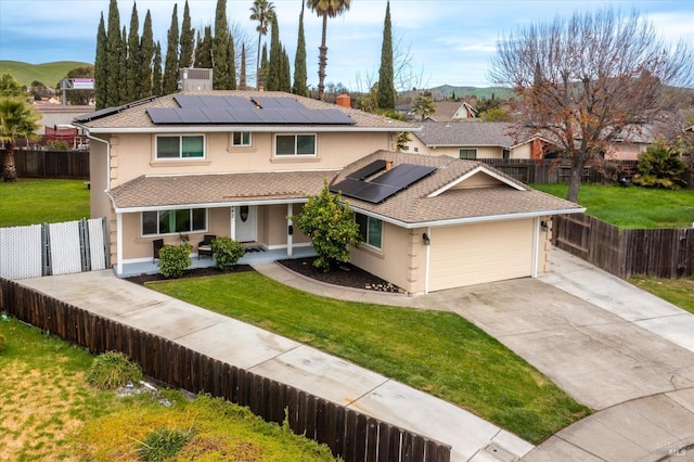 traditional-style home with a porch, fence, concrete driveway, stucco siding, and a front yard