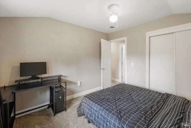 carpeted bedroom featuring vaulted ceiling, a closet, visible vents, and baseboards