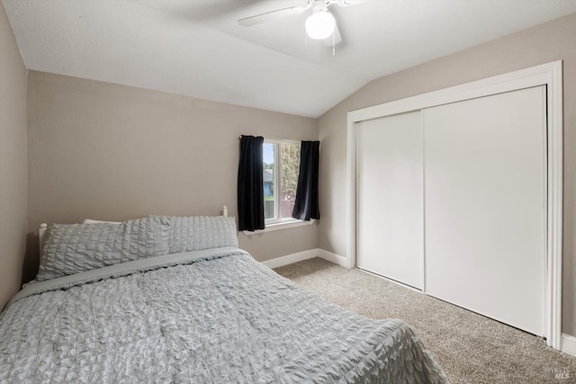 carpeted bedroom featuring lofted ceiling, a closet, ceiling fan, and baseboards